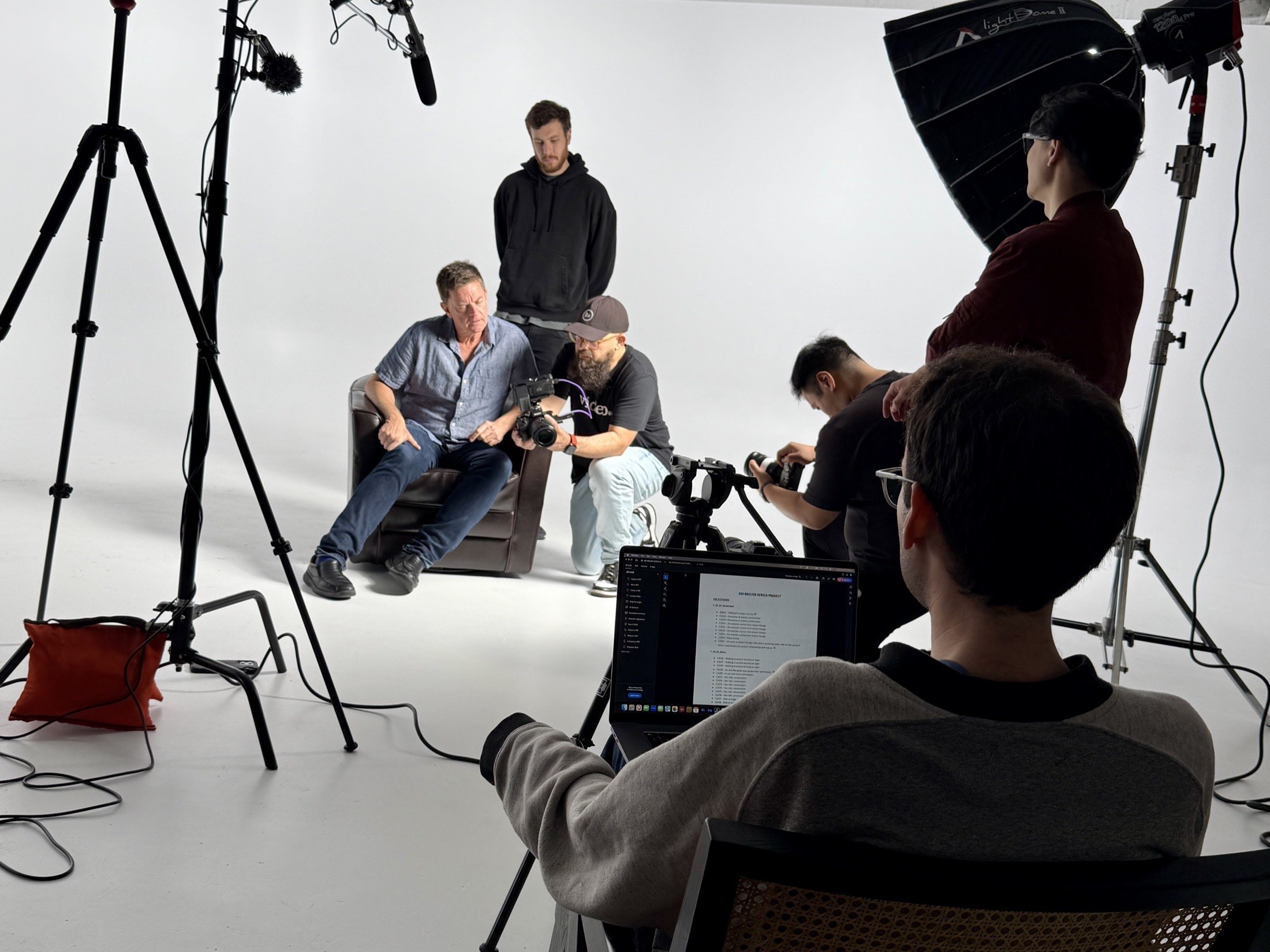 The Ethereal Media crew on a video production set in a white-cyc studio, directing an interview